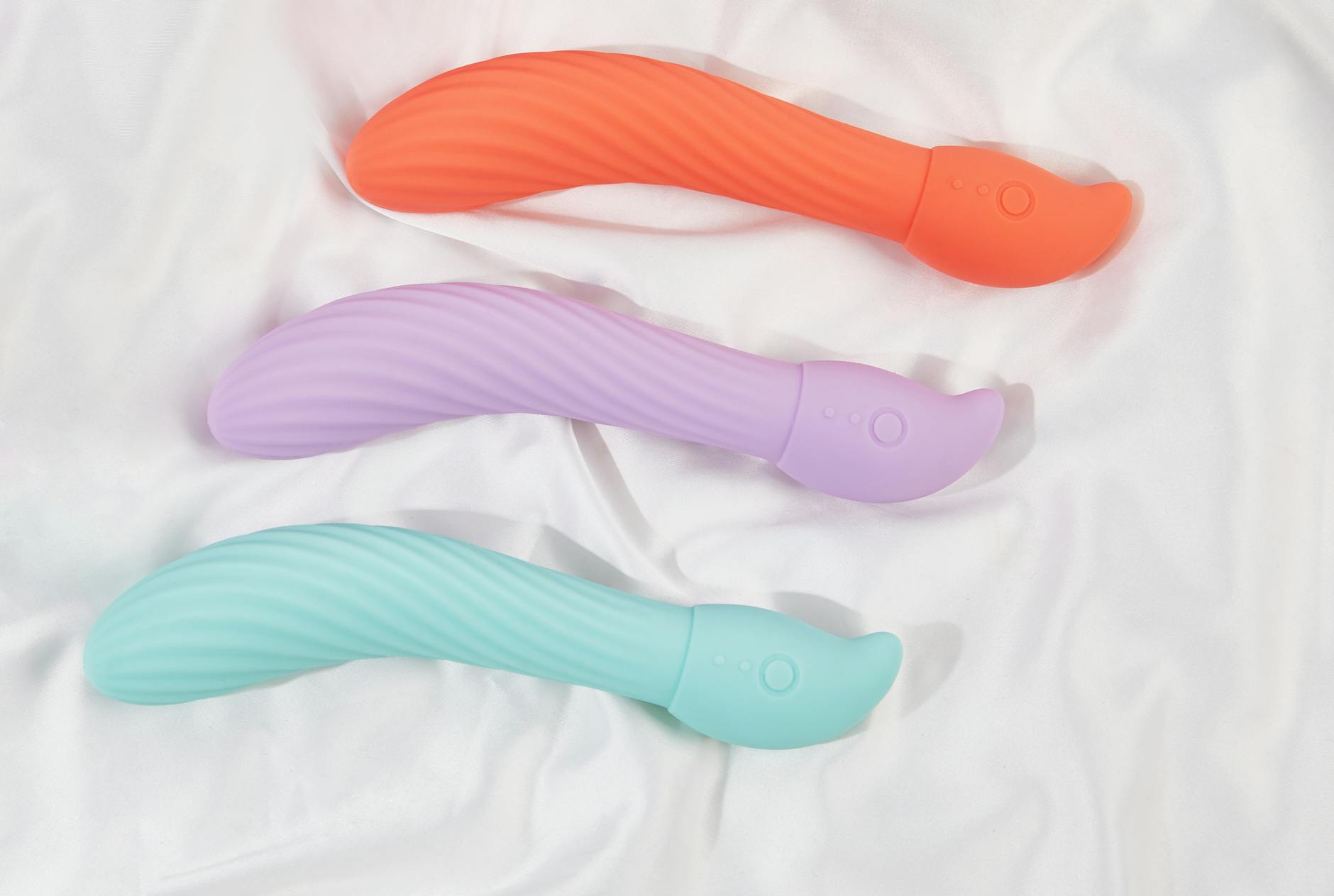 Junge Frau mit Brille hält einen blauen und rosa Lemon-Vibrator in der Hand, symbolisiert Selbstvertrauen und Selbstentdeckung