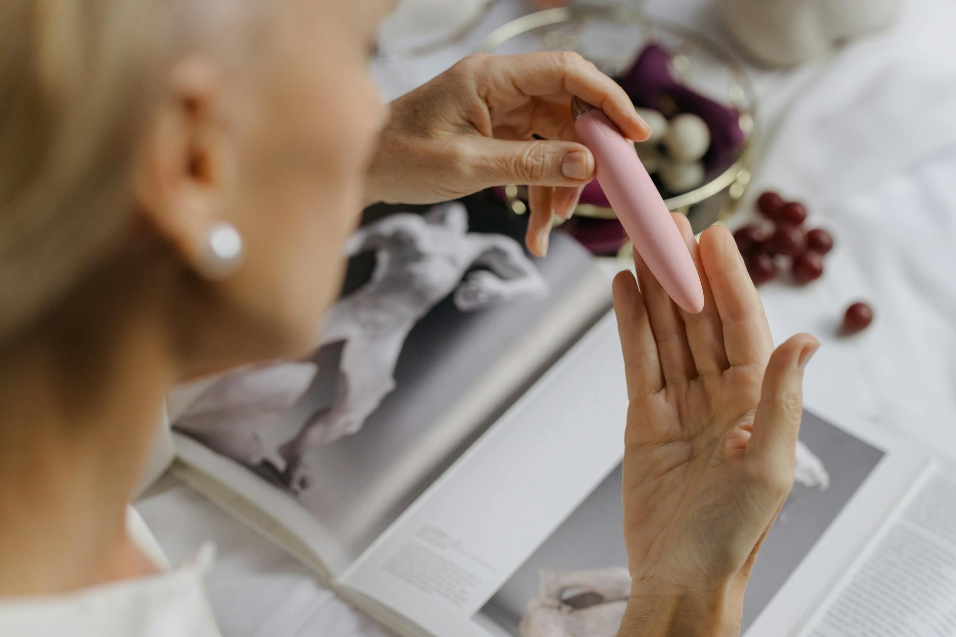 Nahaufnahme einer Frau mit einem rosa Vibrator, die intime Selbstpflege nach der Geburt zeigt