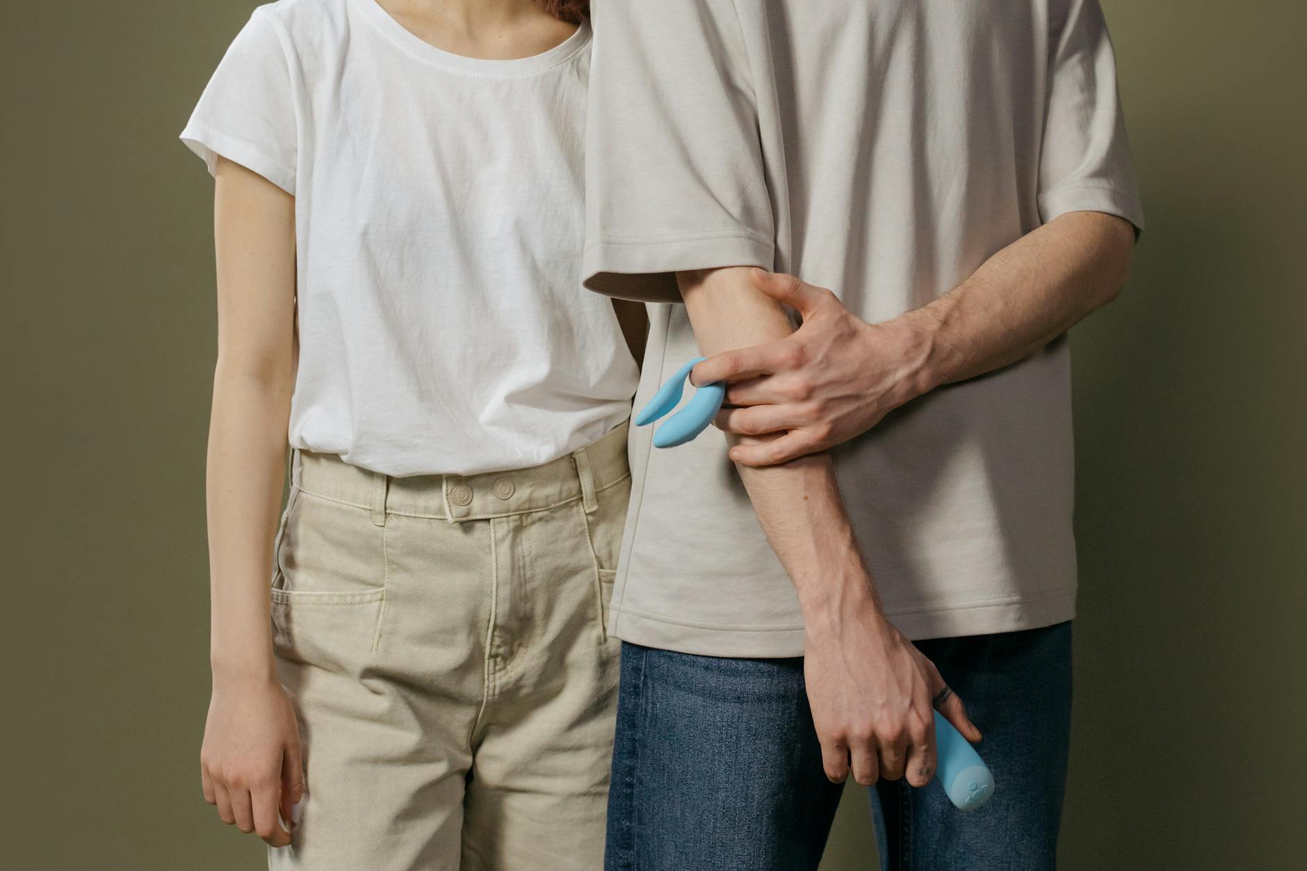 Ein Paar hält gemeinsam einen blauen Vibrator in den Händen und symbolisiert moderne Paarerintimität
