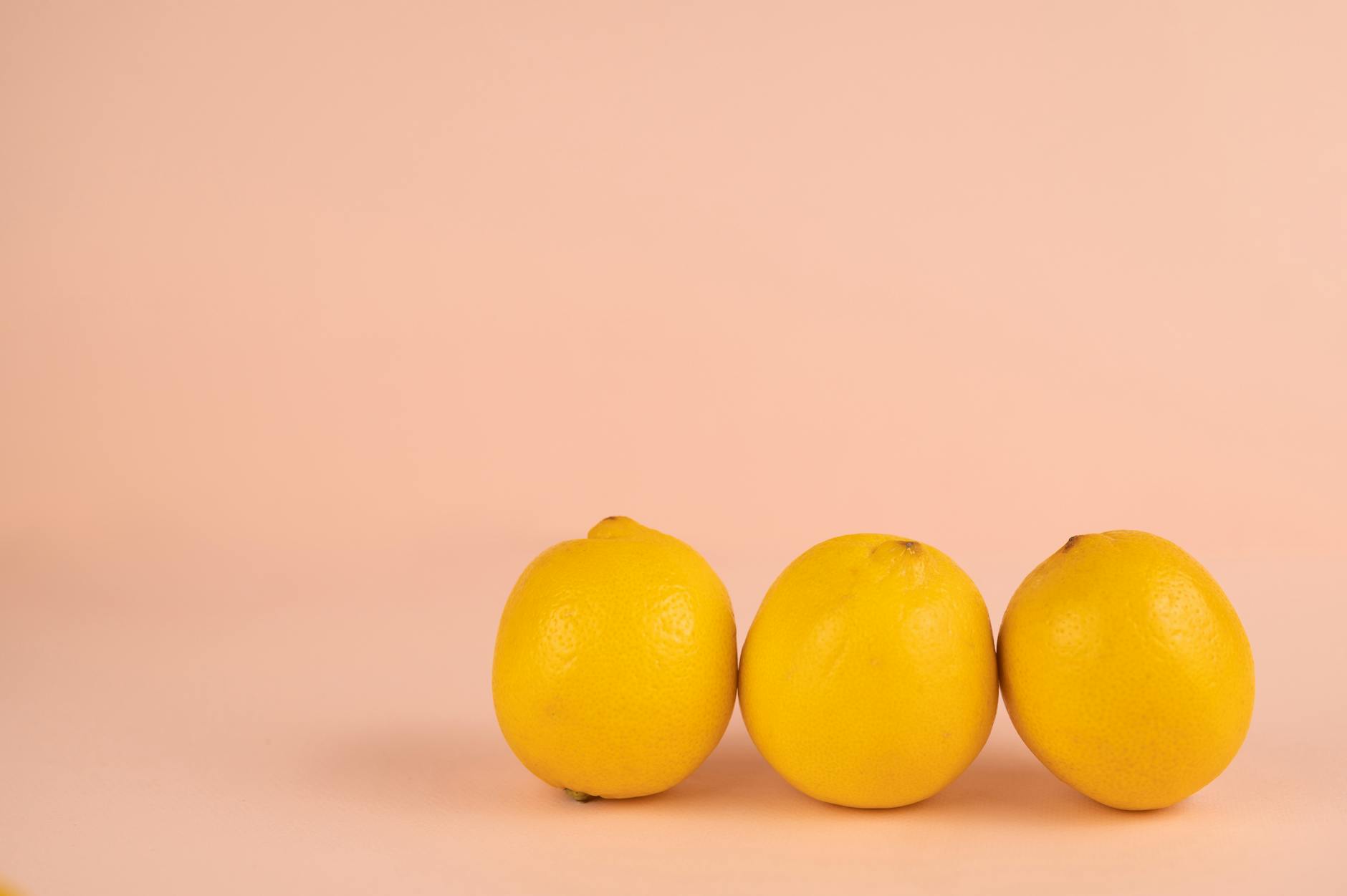 Hand hält einen orangefarbenen Vibrator vor lila Hintergrund, moderne Sinnlichkeit